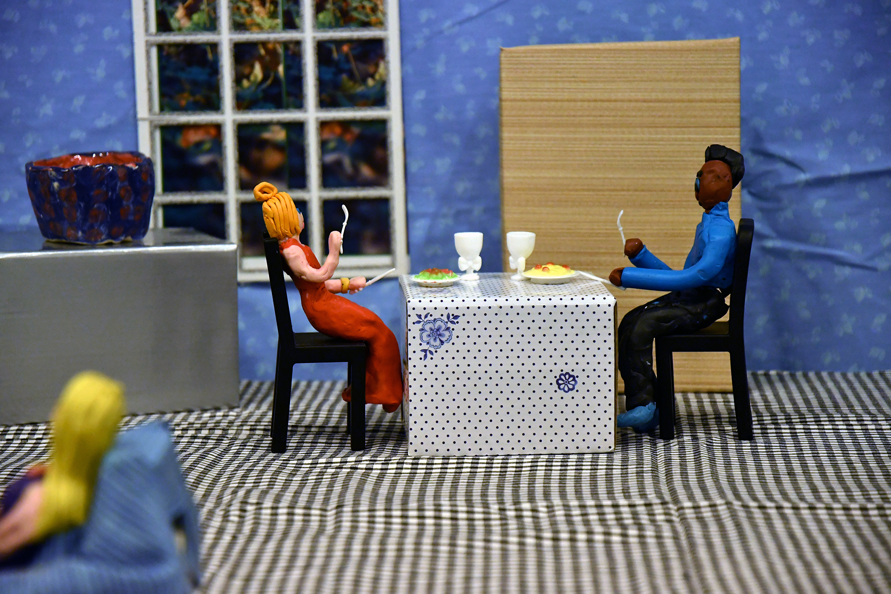 dwie figurki z plasteliny, siedzą przy stole