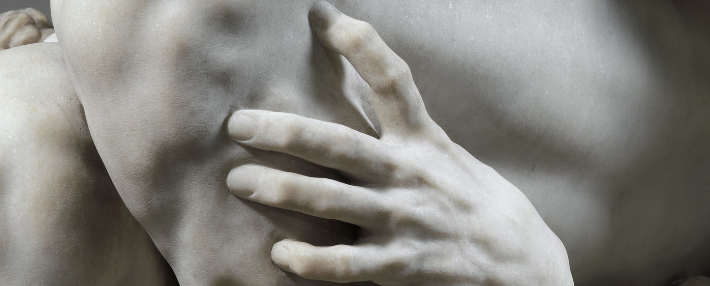 Fragment rzeźby. Widoczna dłoń dotykająca ciała.